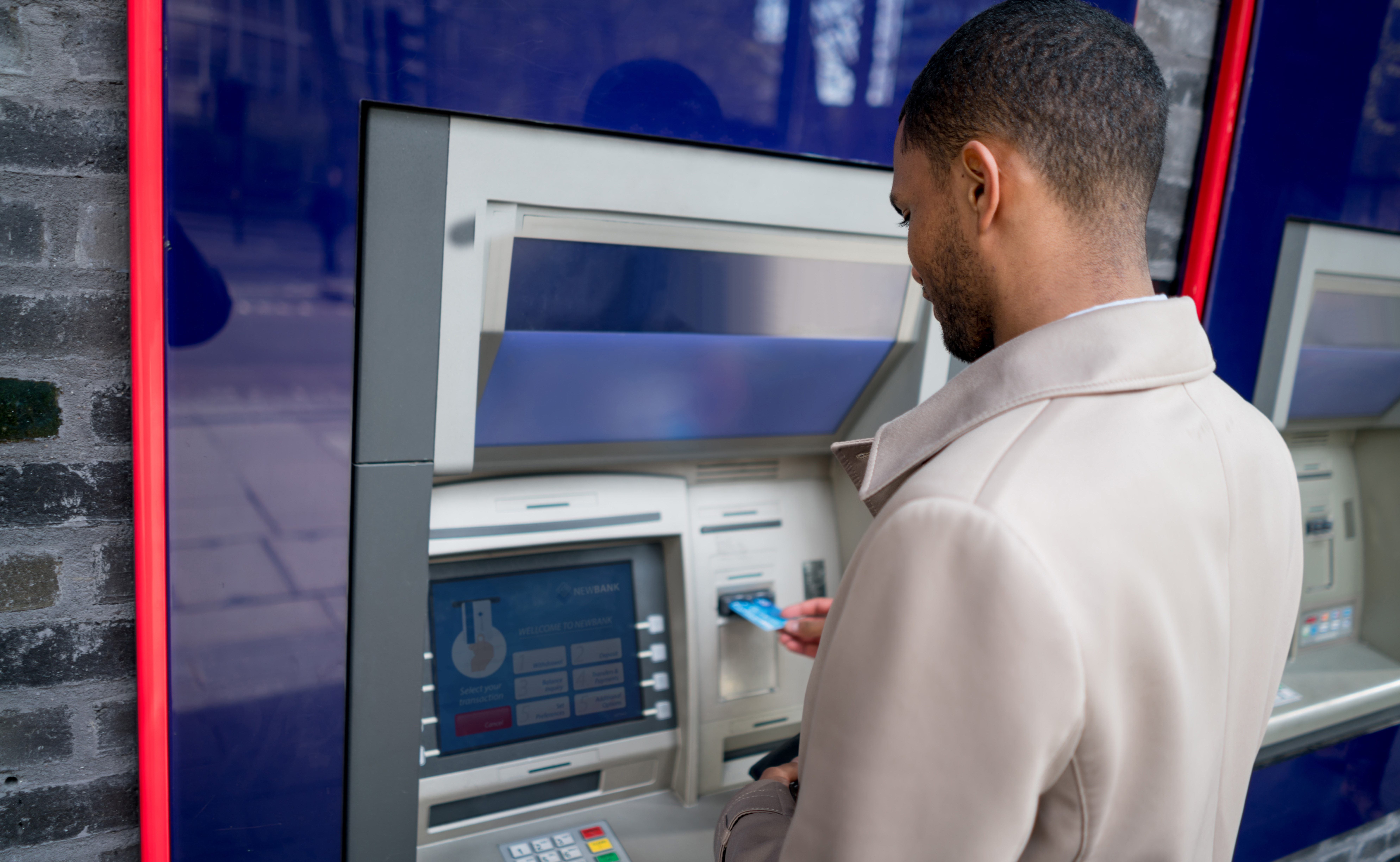 man standing in front of ATM machine